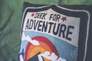 A fabric cushion displaying Seek for Adventure